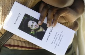 A family friend holds the funeral program for Darrien Hunt following his funeral Thursday, Sept. 18, 2014, in Saratoga Springs, Utah.  Friends and family of the young black man fatally shot by Utah police remembered him Thursday as a shy, gentle and wise man who loved art and music and was trying to find his way through a transition into adulthood.  Hunt was killed on Sept. 10 in a strip mall in the upscale city south of Salt Lake City. The fatal shooting didn't get much attention until Hunt's mother came out days later and said she believed her son was shot because he was black. Authorities, however, say race played no role in the shooting. They say officers were reacting to Hunt lunging at them with a sword that had a 2.5-foot steel blade.(AP Photo/Rick Bowmer)