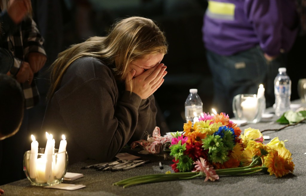 A young woman grieves at a vigil held for victims of a Washington school shooting that occurred on Oct. 24. There is debate over whether teachers carrying guns will improve safety on high school and college campuses.