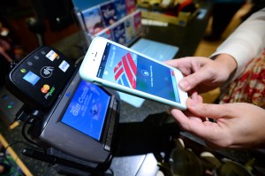 Apple Pay is used by holding the phone over the NFC chip reader allowing the user to make a quick and secure purchase. Apple Pay debuted Sept. 20 on the new iPhone 6 and 6 Plus in 222,000 stores nation-wide.  (Photo by Jordan Strauss/Invision for Disney Store/AP Images)