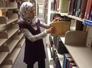 Adhari Zayneb, who is Muslim, selects a book from the Harold B. Lee Library. Zayneb is part of the Muslim minority at BYU. (Photo by Lucy Schouten).