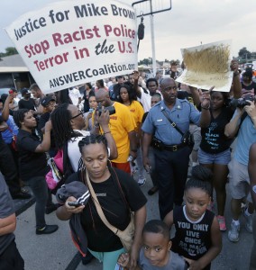 People protest the police shooting death of Michael Brown in Ferguson, Mo. Missouri police have been taking a refresher course on people's constitutional rights while simultaneously stocking up on new riot gear in advance of a grand jury decision on whether to charge a white police officer who fatally shot a black 18-year-old in suburban St. Louis. (AP Photo/Charlie Riedel, File)