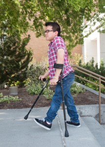 Zayne Callahan walks across the BYU campus. Callahan was born with spina bifida, but after undergoing surgery, was able to begin walking with the help of crutches. (Elliot Miller)