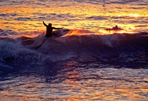 A surfing catching some sunset waves at Huntington Beach Calif.
