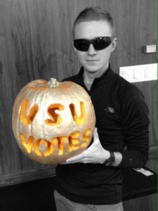 Utah State student Andy Arnes shows off his creative way to promote the Campus Cup competition. Students must post a picture of their "I voted" sticker or sealed absentee ballot on social media to be counted.