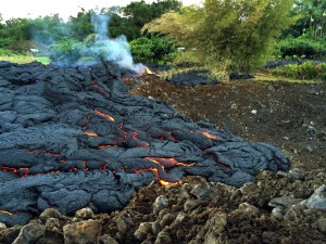 This Oct. 30, 2014 photo from the U.S. Geological Survey shows a breakout of lava oozing from the margin of the lava flow near the town of Pahoa on the Big Island of Hawaii. Lava from a vent at Kilauea volcano has been sliding northeast toward the ocean since June. The lava flow has slowed but largely has remained on course. Pahoa residents say the lava will reshape the community yard by yard as it creeps toward the ocean. (AP Photo/U.S. Geological Survey)
