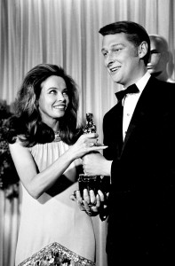 French actress-dancer Leslie Caron presents the Oscar for best director for the movie "The Graduate" to director Mike Nichols at the 1967 Academy Awards at the Santa Monica Civic Auditorium in Santa Monica, Calif. Nichols, the director of matchless versatility who brought fierce wit, caustic social commentary and wicked absurdity to such film, TV and stage hits as "The Graduate," `'Angels in America" and "Monty Python's Spamalot," died Thursday, Nov. 20, 2014. He was 83. (AP Photo/File)