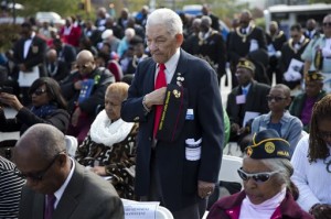 Al Willis, a Montford Point Marine, places his hand over his heart during a ceremony on Veterans Day, Tuesday, Nov. 11, 2014, at the The All Wars Memorial to Colored Soldiers and Sailors in Philadelphia. Americans marked Veterans Day on Tuesday with parades, speeches and military discounts, while in Europe the holiday known as Armistice Day held special meaning in the centennial year of the start of World War I. (AP Photo/Matt Rourke)