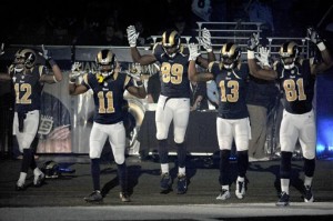 Rams players, from left; Stedman Bailey (12), Tavon Austin (11), Jared Cook, (89) Chris Givens (13) and Kenny Britt (81) raise their arms in awareness of the events in Ferguson, Mo., as they walk onto the field during introductions the Rams' game against the Oakland Raiders on Nov. 30. (AP Photo/L.G. Patterson, File)