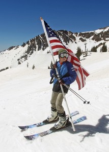 FILE - In this May 26, 2014, file photo, Carter Budge, 11, of Sandy, Utah, skis with a flag during the Snowbird Ski Resort's final day of skiing and riding for the 2013/14 winter season, in Little Cottonwood Canyon in the Wasatch Range, outside of Salt Lake City. Buoyed by an improving economy and renewed buzz about Utah's ski scene thanks to Vail Resort's recent purchase of the state's largest resort, ski officials are expecting one of the best seasons in recent memory when lifts turn on later this month. Bookings at ski resorts are up about 4 percent from the same time last year, said Nathan Rafferty, president of the trade group Ski Utah. After two straight subpar years of snowfall, resorts are optimistic they're due for at least an average year. (AP Photo/Rick Bowmer, File)