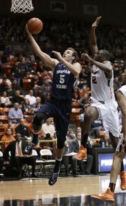 BYU guard Kyle Collinsworth goes to the basket past Pacific forward Eric Thompson during the first half of an NCAA college basketball game in Stockton, Calif., Thursday, Jan. 15, 2015. (AP Photo/Rich Pedroncelli)