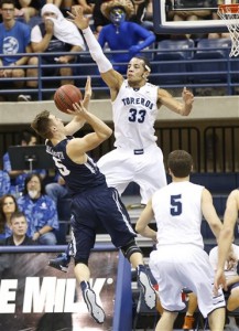 San Diego center Jito Kok (33) forces BYU guard Kyle Collinsworth, left, into a difficult shot during the closing seconds of San Diego's 77-74 victory in an NCAA college basketball game Saturday, Jan. 24, 2015, in San Diego. (AP Photo/Lenny Ignelzi)