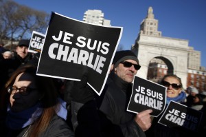 Attendees hold "Je Suis Charlie" (I am Charlie) signs as several hundred people gather in solidarity with victims of two terrorist attacks in Paris, one at the office of weekly newspaper Charlie Hebdo and another at a kosher market, in New York's Washington Square Park, Jan. 10. (AP Photo/Jason DeCrow)