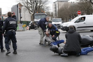 Police officers detain youth who riding a scooter outside a hostage-taking situation at a kosher market in Paris, Friday Jan.9, 2015. France's anti-terrorism prosecutor says a shooting and hostage-taking attack is underway at a kosher market on the eastern edge of Paris. A police official said there are multiple hostages and wounded at the scene. It is not known if the two youths were involved in the hostage taking situation. (AP Photo/Francois Mori)