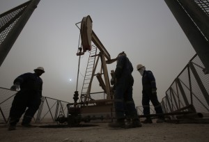Workers use a mechanized drill to obtain oil. Projections are that although gas prices have gone down, Congress will not raise taxes on gas this year. (Associated Press)