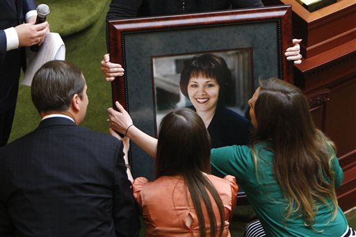 Stan Lockhart, Hannah Lockhart and Emily Britton accept a portrait in honor of former Speaker of the House Rebecca Lockhart during the opening day of the legislative session in Salt Lake City, Monday, Jan. 26, 2015. Members of the House of Representatives used their first vote of the year to unanimously pass a resolution honoring former House Speaker Rebecca "Becky" Lockhart, who died just over a week ago from a rare brain disease at age 46. They also wore pins featuring her initials on their lapels. (AP Photo/The Deseret News, Chelsey Allder)