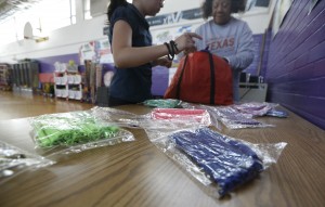 Physical education teacher Sharon Foster, left, helps Nelda Rodriguez, 9, lay out "Y-Ties" no tie shoelaces that are sold as a fund raiser at James Bowie Elementary in Dallas. Many states have decided that school fundraiser's need to be healthier and following this lead the school's PE teacher converted the school from selling chocolate bars to selling shoelaces that kids like. ( Photo courtesy AP)