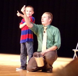 Theron Christensen invites a child onstage to participate in his trick. Christensen has been performing magic professionally for four years. (Theron Christensen)