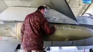 A Jordanian air force pilot writes a message to Islamic State militants on a missile at Mowafak Al-Salti airbase in Azraq, Jordan. King Abdullah II has thrust Jordan to the center of the war against the Islamic State group with his pledge of relentless retaliation for the killing of one of his pilots. (AP Photo/Jordanian military via Roya TV)