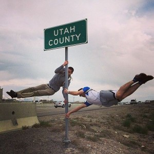 Two teammates balance from a Utah County sign during the Questival. Utah was home to the first-ever Cotopaxi Questival in 2014. (Cotopaxi)