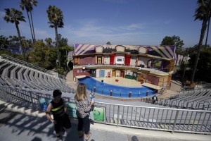 People look at the empty stadium where SeaWorld normally hosts its "Sea Lions Live," show Tuesday, March 10, 2015, in San Diego. SeaWorld is temporarily shutting down its sea lion and otter show to let staff help rescue stranded sea lion pups. It will give trainers time to help the park's animal rescue team in dealing with sick and emaciated pups. (AP Photo/Gregory Bull)