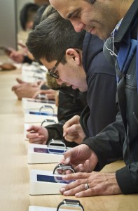 Customers examine Apple's new watch, which could only be bought pre-order online, Friday, April 10, 2015, in New York. The first new gadget under CEO Tim Cook is selling in eight countries and Hong Kong, with shipments scheduled to start April 24. (AP Photo/Bebeto Matthews)