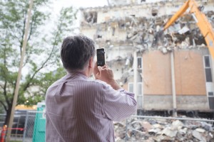 Onlookers take photos and videos of the demolition. The high-reach demolition machines are strong enough to tear apart steal beams inside the building. (Maddi Dayton)