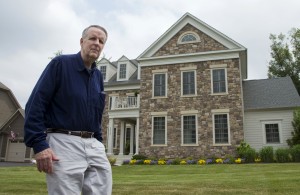 John Ryan poses for a picture in front of his house in Aldie, Va., Friday, May 29, 2015. For the first time, a major study has shown that a drug targeting the body's disease-fighting immune system may improve survival for the most common form of lung cancer. Ryan was diagnosed with incurable lung cancer two years ago. Standard cancer medicine left him exhausted, prone to infections and did little to shrink the tumor. In October 2013 he joined the immunotherapy study and was randomly assigned to get Opdivo. Three months later his tumor had been reduced by 65 percent and he felt well enough to help his son cut down a large tree for firewood. (AP Photo/Manuel Balce Ceneta)