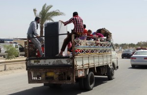 In this Monday, May 18, 2015 photo, civilians fleeing their hometown of Ramadi, Iraq, rides on a truck in Habaniyah town, 80 kilometers (50 miles) west of Baghdad. Iraqi forces and allied Sunni tribesmen repelled an Islamic State attack overnight on a town west of Baghdad, a tribal leader said Tuesday, as the government renewed its commitment to arm anti-militant Sunni tribes following the loss of the key city of Ramadi. (AP Photo)