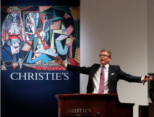 Christie's Global President and auctioneer Jussi Pylkkanen takes bids on Pablo Picasso's Women of Algiers (Version O), which sold for nearly $179.4 million, making it set a world record for artwork at auction during a sale at Christie's Rockefeller Center in New York, Monday, May 11, 2015. Experts say high art prices are driven by artworks' investment value and by wealthy new and established collectors seeking out the very best works.
