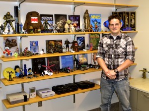 Dr. Kevin John shows off his sizeable collection of video game memorabilia. John's young age helps him relate to his students. (Taylor Ricks)