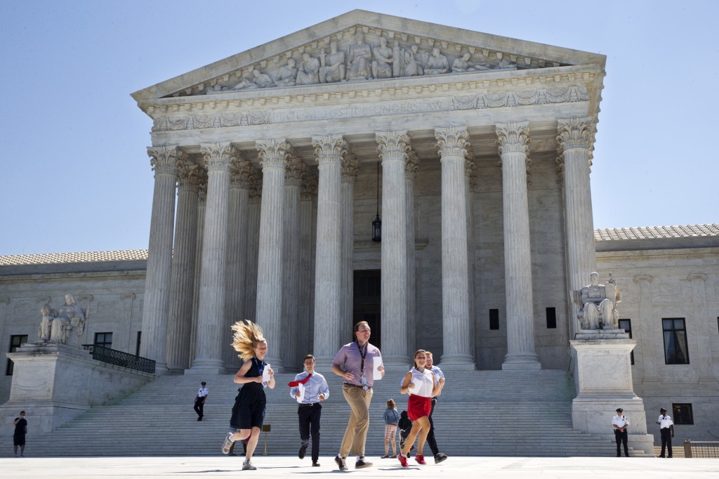New interns run with a decision across the plaza of the Supreme Court in Washington, Monday June 29, 2015. On Monday, the court upheld Arizona congressional districts drawn by an independent commission and rejected a constitutional challenge from Republican lawmakers and upheld the use of a controversial drug in lethal injection executions Monday, as two dissenting justices said for the first time that they think it's "highly likely" that the death penalty itself is unconstitutional. (AP Photo/Jacquelyn Martin)