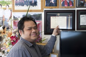 Banyar Marn, a refugee from Burma, showing off his bachelors degree he earned from the University of Utah.