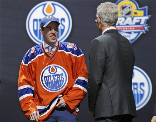 Connor McDavid, left, chats with Craig MacTavish after being chosen first overall by the Edmonton Oilers in the NHL hockey draft, Friday, June 26, 2015, in Sunrise, Fla. (AP Photo/Alan Diaz)