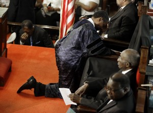 Rev. Norvel Goff prays at the empty seat of the Rev. Clementa Pinckney at the Emanuel A.M.E. Church four days after a mass shooting that claimed the lives of Pinckney and eight others in Charleston, S.C. Some family members of those killed in the church shooting have said they forgive the man who's been charged. But others in the African-American community say offering forgiveness so quickly may not be the best idea. (AP Photo/David Goldman, Pool, File)