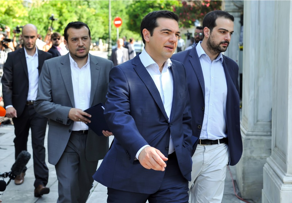 Greek Prime Minister Alexis Tsipras, center, arrives to attend a meeting with Greek political party leaders at the Presidential Palace as Minister of State Nikos Pappas, left, and Government spokesman Gabriel Sakellaridis, right, follow him in Athens, Monday, July 6, 2015. Greek Finance Minister Yanis Varoufakis resigned Monday, saying he was told shortly after Greece's decisive referendum result that some other eurozone finance ministers and the country's other creditors would appreciate his not attending the ministers' meetings.(Giannis Kotsiaris/InTime News via AP) GREECE OUT