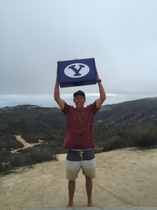 Sean Kimball celebrates with his BYU50 swag box. Kimball won the box by running out of his house without shoes. (BYU Athletics)