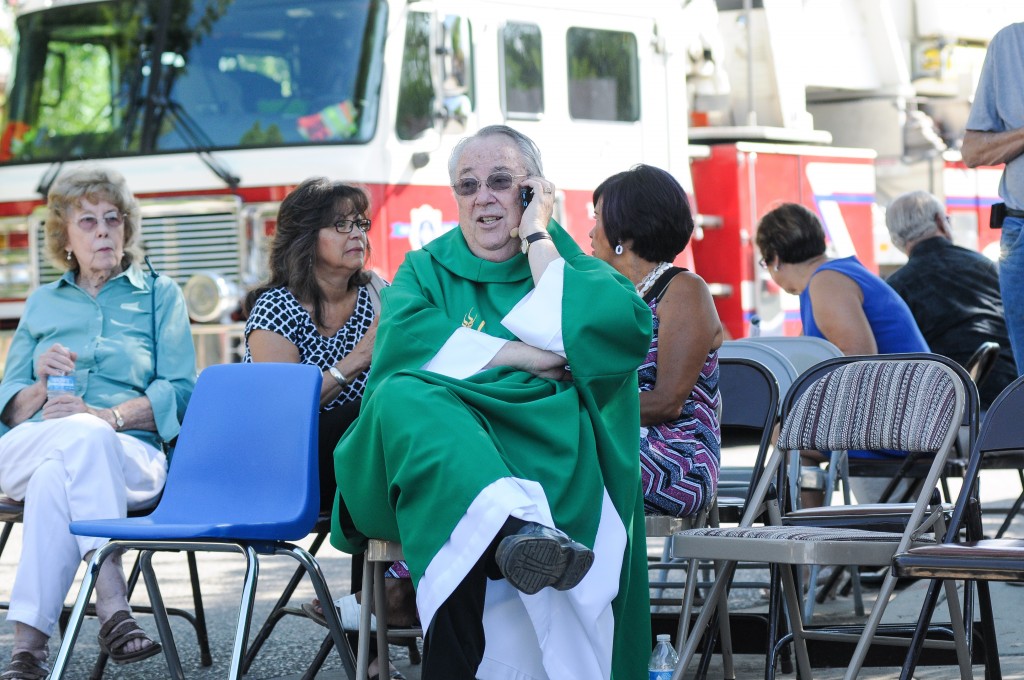While waiting in a staging area, Holy Cross Catholic Church Pastor John Anderson tries to get in touch with other local churches to warn them of the two explosions that occurred and to be vigilant, Sunday, Aug. 2, 2015, in Las Cruces, N.M. Churchgoers were left shaken during Sunday morning services after authorities say explosions occurred less than 30 minutes apart outside two Las Cruces churches. (Robin Zielinski/The Las Cruces Sun-News via AP) MANDATORY CREDIT
