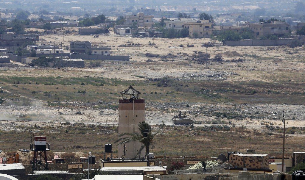 FILE - In this July 2, 2015 file photo, an Egyptian armored vehicle patrols next to a military watch tower on the Egyptian side of the border, seen from the south of the Gaza Strip. The Obama administration is quietly reviewing the future of America's three-decade deployment to the Sinai Peninsula, fearful the lightly equipped peacekeepers could be targets of escalating Islamic State-inspired violence. Options include beefing up their protection or pulling them out altogether. (AP Photo/Adel Hana, File)