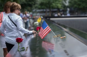 Visitors touch the names of the victims of the Sept. 11 terror attacks at the South Pool of the National September 11 Memorial on Friday, Sept. 11, 2015 in New York. With a moment of silence and somber reading of names, victims' relatives began marking the 14th anniversary of Sept. 11 in a subdued gathering Friday at ground zero. (AP Photo/Bryan R. Smith)