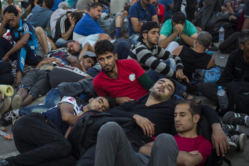 Migrants and refugees wait to be registered by police at the port of Mytilene, on the Greek island of Lesbos, early Sunday, Sept. 6, 2015. (AP Photo/Santi Palacios)