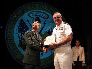 Colonel Ken Alford receiving the Defense Superior Service Medal in June 2008 during his retirement ceremony at the National Defense University in Washington, DC from Rear Admiral Gerard M. Mauer, Jr.)
