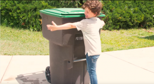 Little boy hugs waste bin as part of a promotional video for Provo's new recycling program. (City of Provo)