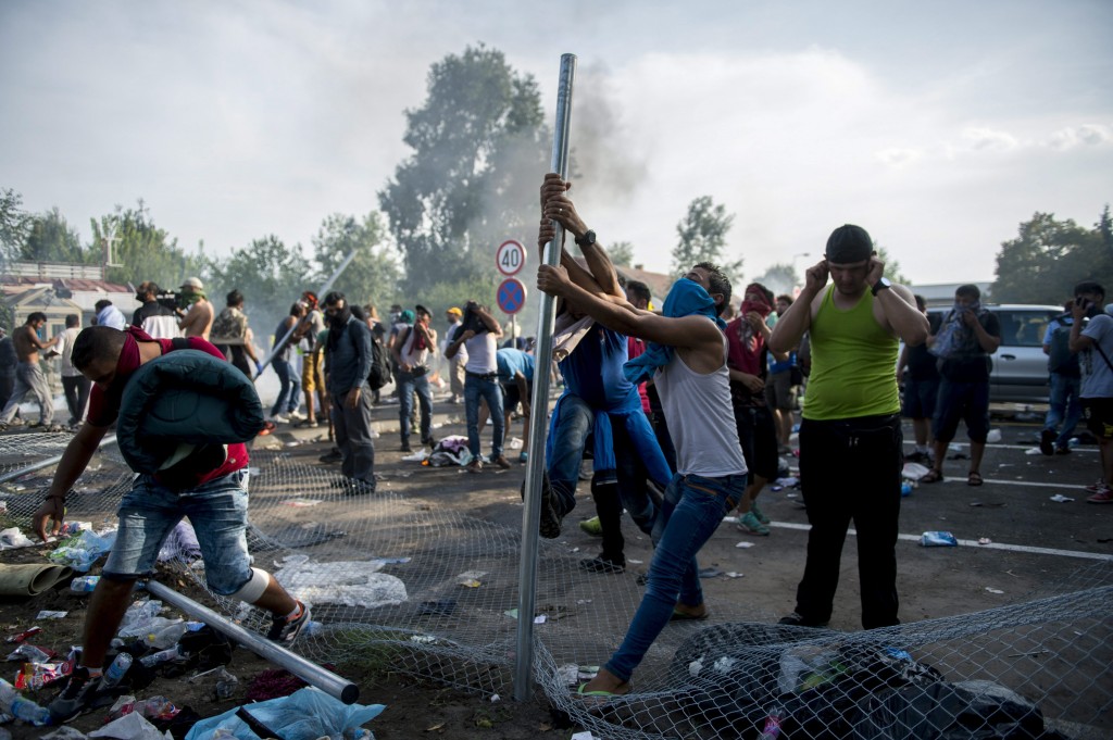 Migrants demonstrate at the border crossing into Hungary, near Horgos, Serbia, Wednesday, Sept. 16, 2015. The border crossing was closed by the Hungarian police after the Hungarian government declared a state of crisis due to mass migration, meaning special measures to fight illegal immigration, in two Hungarian counties bordering Serbia. (Tamas Soki/MTI via AP)