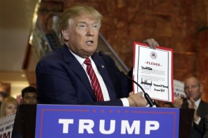 Republican presidential candidate Donald Trump holds a signed pledge during a news conference in Trump Tower, Thursday, Sept. 3, 2015 in New York. Trump ruled out the prospect of a third-party White House bid and vowed to support the Republican Party's nominee, whoever it may be. (AP Photo/Richard Drew)