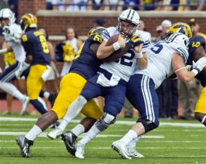 BYU quarterback Tanner Mangum (12) is sacked by Michigan linebacker Noah Furbush (59) in the second quarter of an NCAA college football game in Ann Arbor, Mich., Saturday, Sept. 26, 2015. Michigan won 31-0. (AP Photo/Tony Ding)