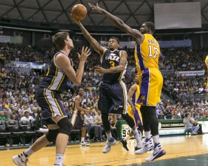 Utah Jazz guard Trey Burke (3), center, goes between Utah Jazz guard Olivier Hanlan (21), left, and Los Angeles Lakers center Roy Hibbert (17) during the second half of an NBA preseason basketball game, Tuesday, Oct. 6, 2015, in Honolulu. The Jazz defeated the Lakers 117-114. (AP Photo/Marco Garcia)