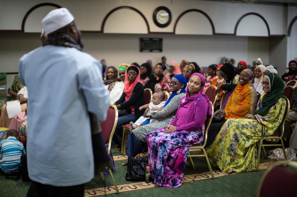 In this Sunday, Aug. 30, 2015 photo, Imam Suleimaan Hamed, left, speaks to members of the Atlanta Masjid of Al Islam mosque in Atlanta. Members of the mosque gathered to celebrate a group of pilgrims who will make the annual Hajj pilgrimage to the holy city of Mecca. (AP Photo/Branden Camp)