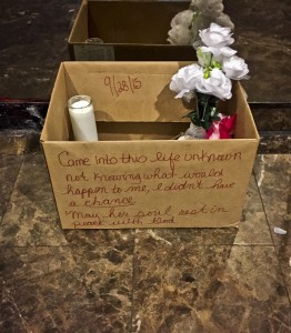 A makeshift memorial for a newborn who died after being tossed from a seventh floor apartment window, sits in the building's lobby, Wednesday, Sept. 30, 2015, in New York. Jennifer Berry, 33, who is accused to have given birth in the bathroom of her boyfriend's apartment before tossing her newborn daughter to her death, is being held without bail Wednesday on a murder charge. (AP Photo/Michael Balsamo)