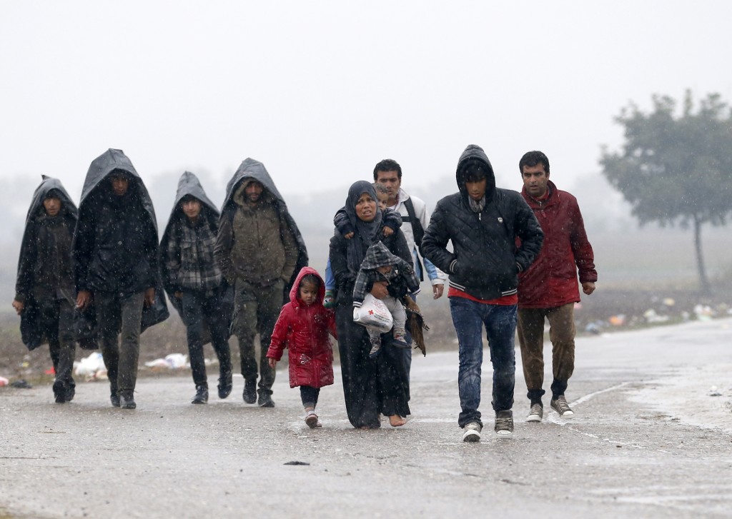 A group of migrants walk on the road near a border line between Serbia and Croatia, near the village of Berkasovo, Serbia, Monday, Oct. 19, 2015. Tension was building among thousands of migrants as they remained stranded in fog and cold weather in the Balkans on Sunday in their quest to reach a better life in Western Europe, two days after Hungary closed its border with Croatia and the flow of people was redirected to a much slower route via Slovenia. (AP Photo/Darko Vojinovic)