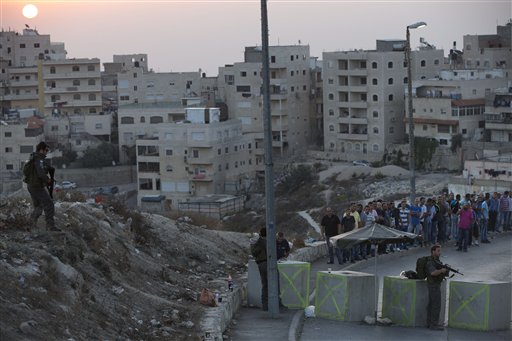 Israeli border police check Palestinians ID at a checkpoint as they exit the Arab neighbourhood of Issawiyeh in Jerusalem, Sunday, Oct. 18, 2015. Palestinian assailants carried out a series of five stabbing attacks in Jerusalem and the West Bank on Saturday, as a month-long outburst of violence showed no signs of abating. The unrest came despite new security measures that have placed troops and checkpoints around Palestinian neighbourhoods in east Jerusalem. (AP Photo/Oded Balilty)